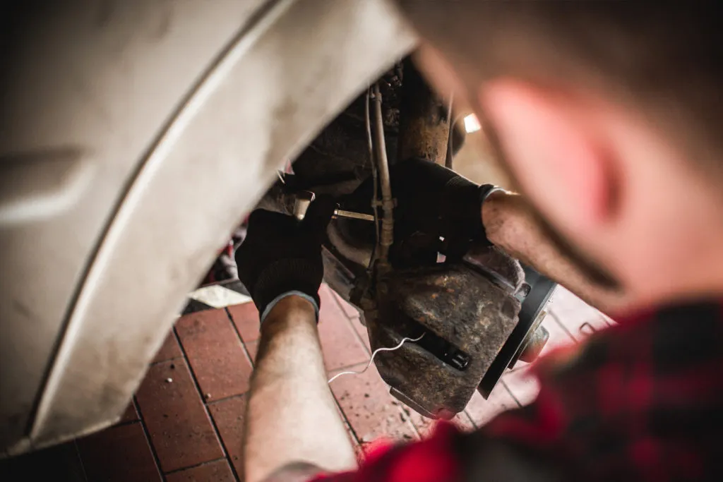 Mechanik pracujący przy zacisku hamulcowym Peugeota 508